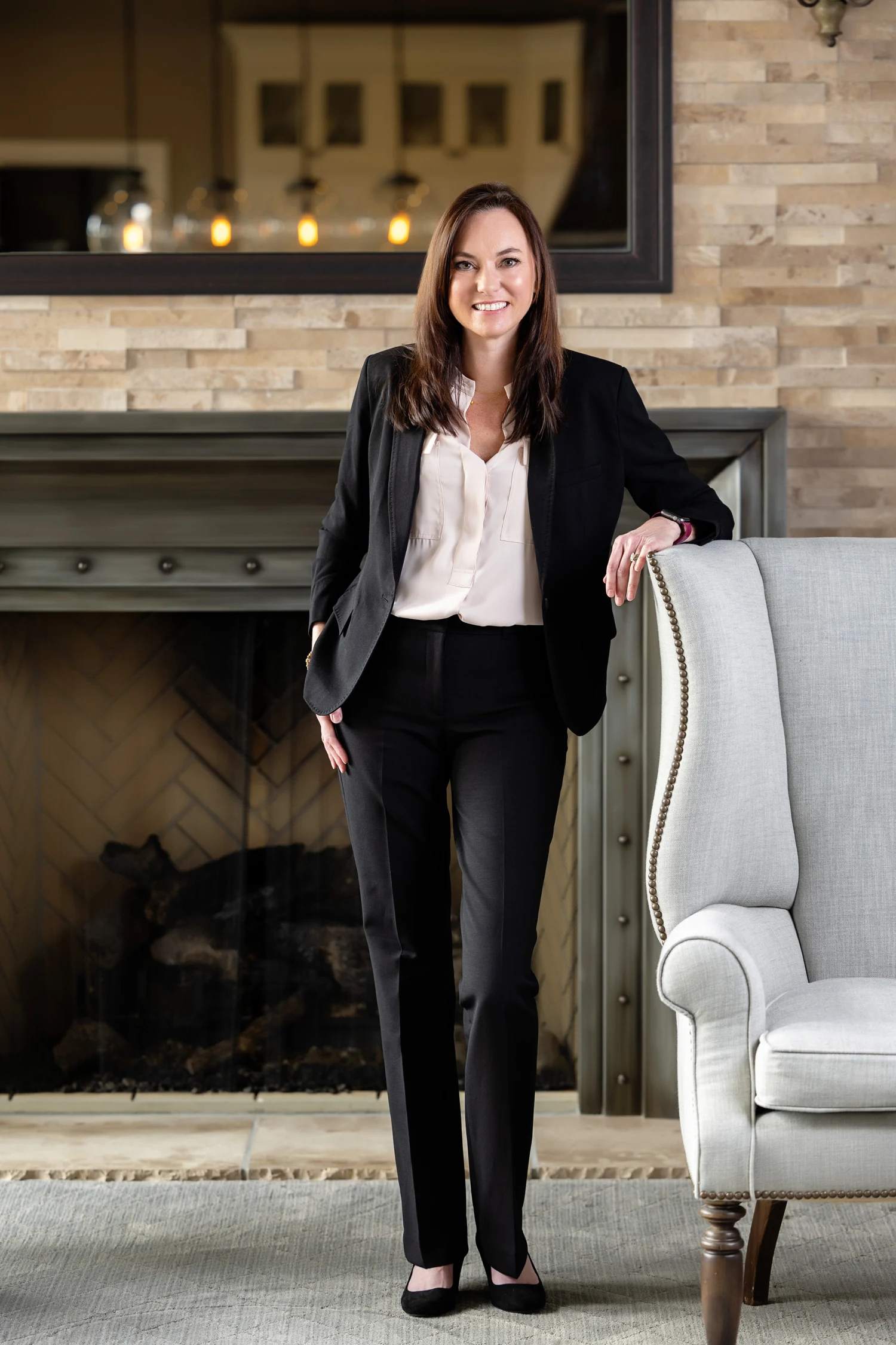 Jolie Abreu standing beside a comfortable armchair